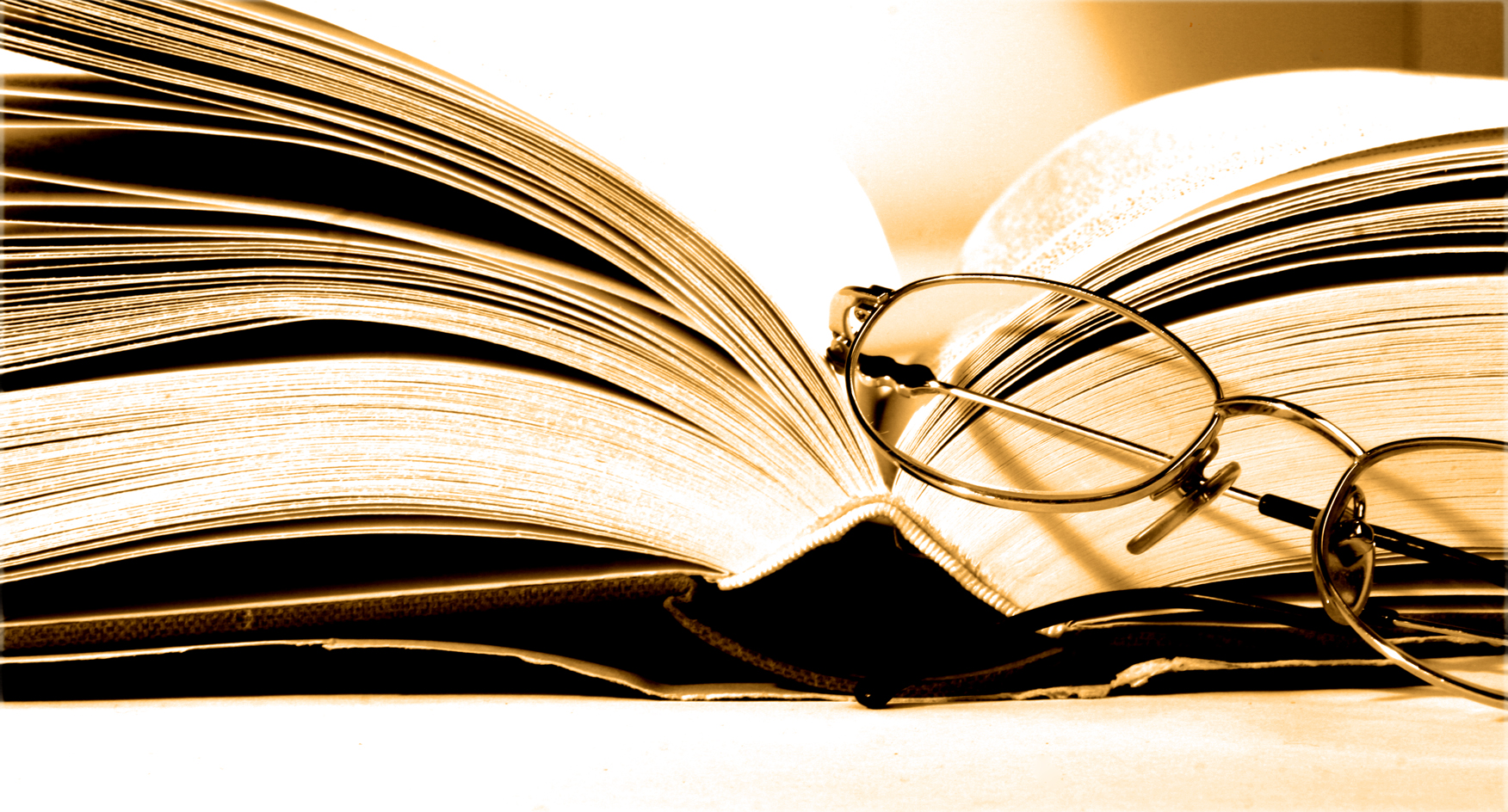 A pair of spectacles resting on an open book. Photo by just4you on Freeimages.