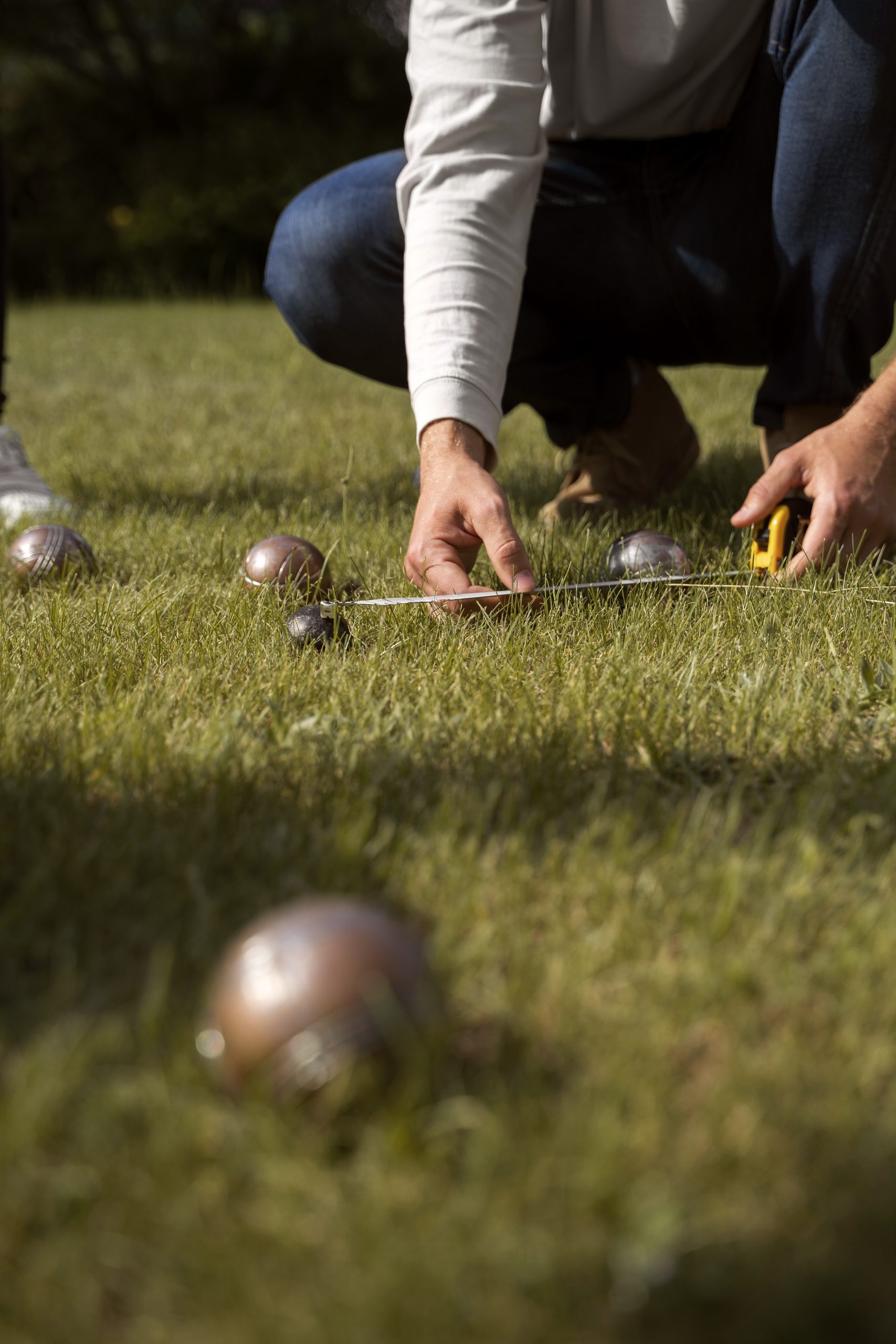 Measuring in a game of Petanque. Image from Free Pix.