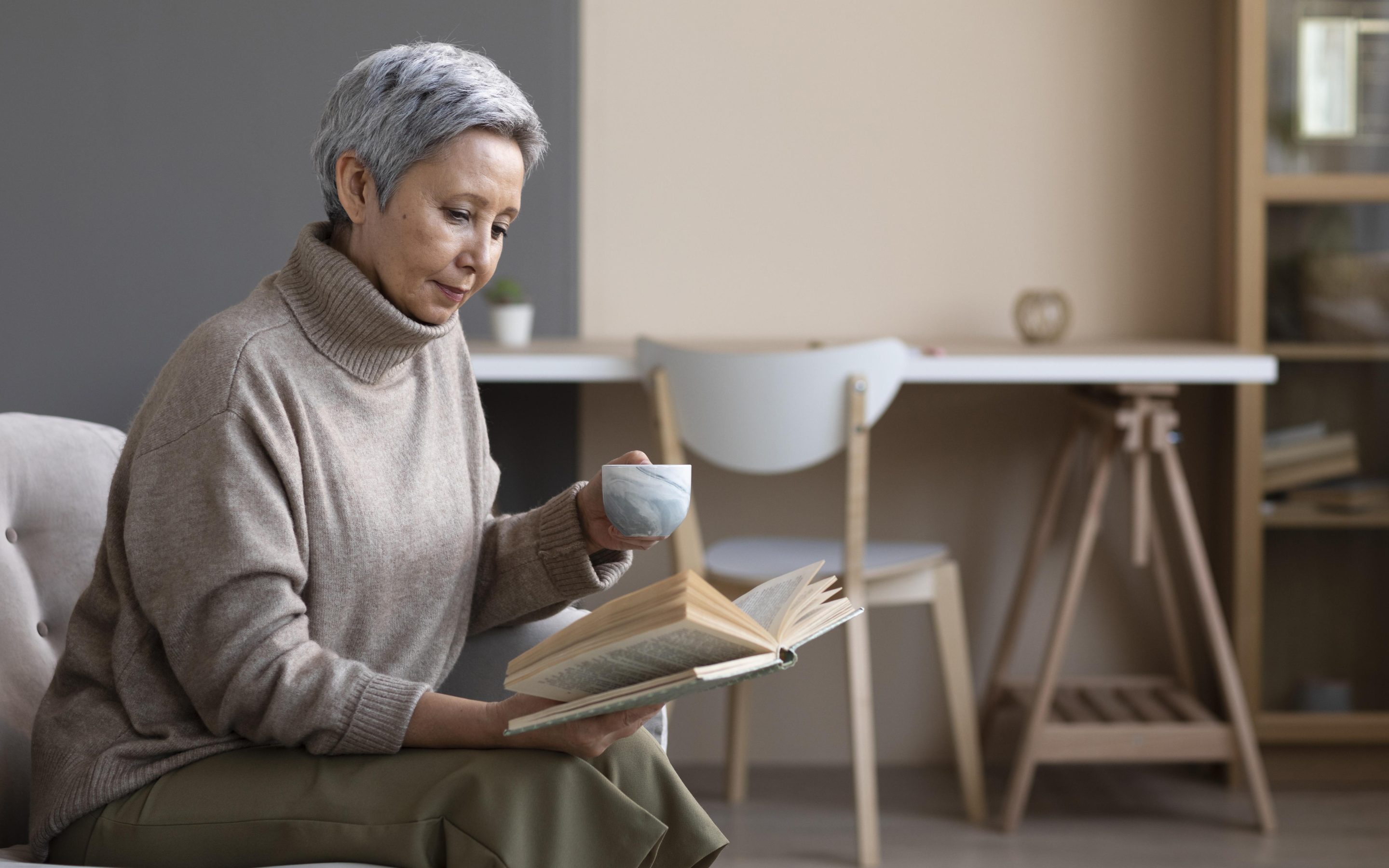 A woman drinking tea and reading her book. Image 10847308 from Freepik.